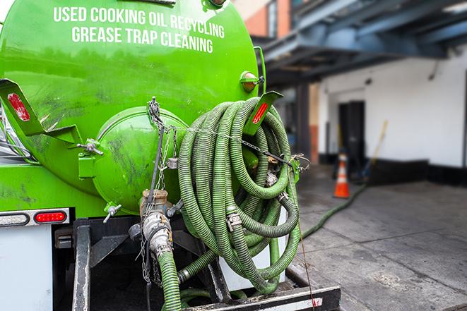 a grease trap pumping service in action at a commercial building in Bagdad, FL